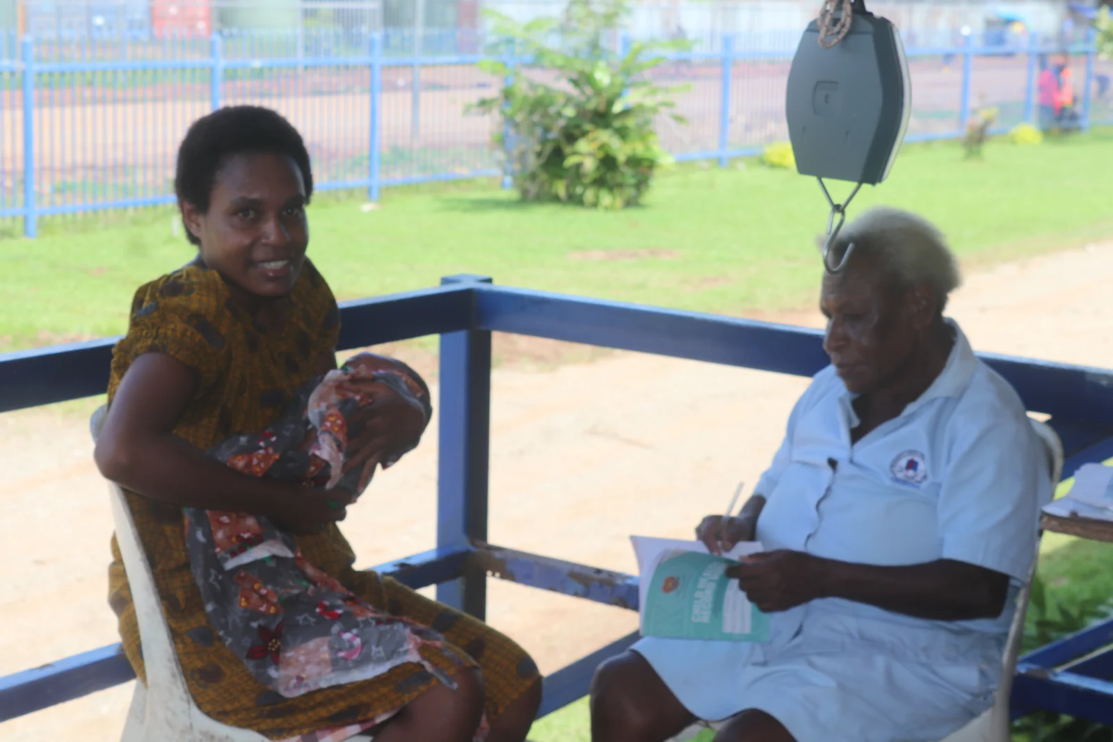 At ECPNG Balimo Rural District Hospital, long-serving CHW Miliyato Mili supports child vaccination services while recording p